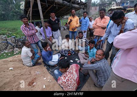 Uomini che giocano le carte in un villaggio nel villaggio di Kumrokhali, Bengala Occidentale, India Foto Stock