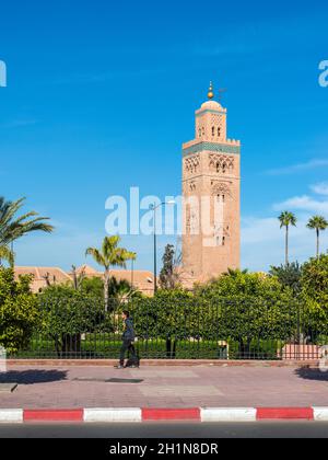 Marrakech, Marocco - 8 Dicembre 2016: un pedone in background della Moschea di Koutoubia (Kutubiyya Moschea) - la più grande moschea di Marrakech, Mo Foto Stock