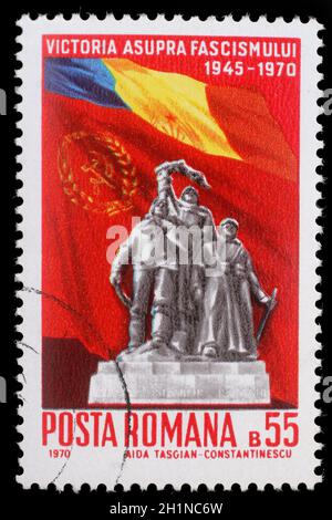 Timbro stampato in Romania mostra il Monumento della Vittoria e le bandiere della Romania e URSS venticinque anni - la vittoria sul fascismo, circa 1970. Foto Stock