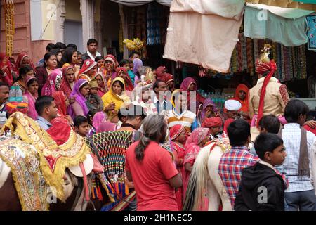 Il giovane sposo su un cavallo conduce la festa di nozze alla casa della sposa in Pushkar, Rajasthan, India Foto Stock