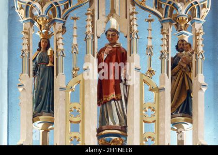 Santi Barbara, Lawrence e Giuseppe, statue sull'altare maggiore nella chiesa parrocchiale di San Giorgio a Desinic, Croazia Foto Stock