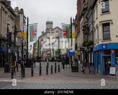 Cardiff High Street con bandiere che mostrano il drago gallese visto da Castle Street Foto Stock