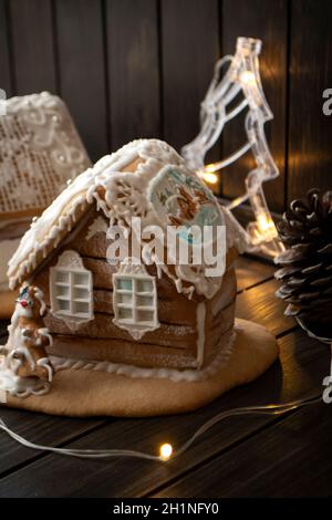 Bella casa di pan di zenzero fatta a mano per Natale e Capodanno, backround scuro, immagine verticale Foto Stock