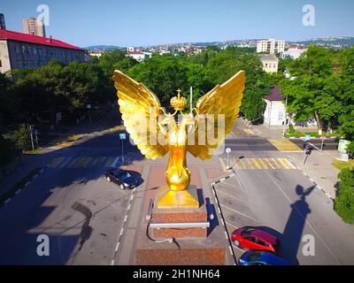 un monumento a due teste un'aquila dorata. Foto Stock