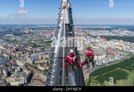 I lavoratori installatori in altezza lavorano in cima al grattacielo. Foto Stock