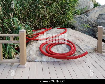 Costruzione sulle rocce. Disposizione dei cavi nelle corrugazioni rosse. Piattaforma di osservazione sulle rocce. Costa del Mar Caspio. Kazakistan. Aktau 16 luglio 2019 Foto Stock