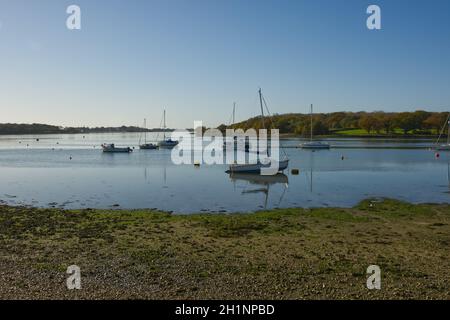 Barche ormeggiate a Dell Quay nel porto di Chichester, West Sussex, Inghilterra. Con cielo blu chiaro e acqua calma piatta. Foto Stock