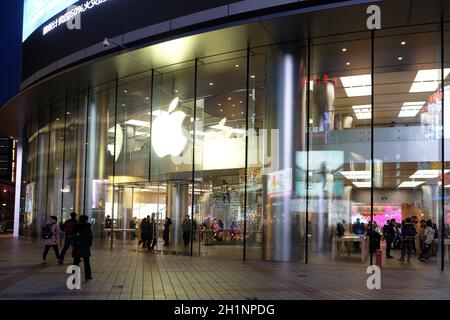 Persone che camminano di fronte all'Apple Store in via Wangfujing a Pechino, Cina Foto Stock