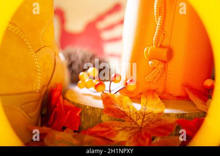 Hunter sacchetto arancione su una lastra di legno accanto all'arancione e bacche rosse e foglie e uno stivale con un pinecone e una mano rossa tacchino sullo sfondo Foto Stock