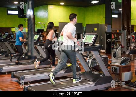 Gruppo di persone che corrono su tapis roulant nella moderna palestra sportiva. Foto di alta qualità Foto Stock