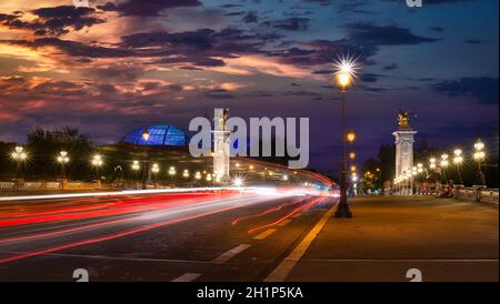 Traffico sul ponte Alexandre III a Parigi al tramonto Foto Stock