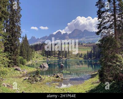 Il Lago Carezza è un piccolo lago alpino delle Dolomiti, a 25 km da Bolzano in Alto Adige. Il lago si trova nelle Dolomiti occidentali ai margini di Foto Stock