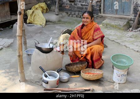 Il modo tradizionale di fare cibo sul fuoco aperto nella vecchia cucina in un villaggio, Kumrokhali, West Bengal, India Foto Stock