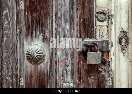 Serratura arrugginita con serratura imbullonata su porta in legno intemperato, Valletta, Malta, Europa Foto Stock