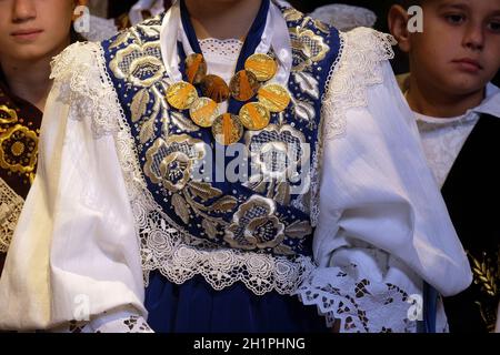 Ragazza vestita in regionali tradizionali costumi folk in chiesa durante la Santa Messa il giorno del Ringraziamento in Stitar, Croazia Foto Stock