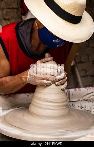 Uomo che fa gli articoli di ceramica sulla ruota dei vasai in un Fabbrica tradizionale nella città di Ráquira situata nel Dipartimento di Cundinamarca in Colombia Foto Stock