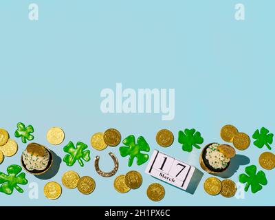 Concetto di giorno di San Patrizio con spazio per la copia. Vita morta moderna con simboli fortunati e cibo dolce per la festa di San Patrizio. Cupcake in velluto verde, frassino Foto Stock