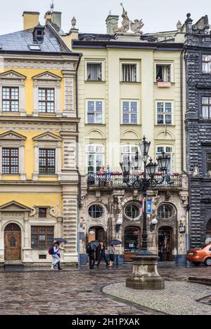 Lviv, Ucraina - 31 Maggio 2016: pedoni con un ombrelloni sulle stradine della vecchia città europea sotto la pioggia di primavera di Lviv, Ucraina. Foto Stock