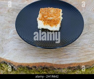 torta al latticello di cocco appena sfornata disposta su fetta di albero Foto Stock