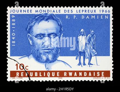 Timbro stampato in Ruanda mostra Padre Joseph Damien, Giornata Mondiale dei Malati di Lebbra, circa 1966. Foto Stock