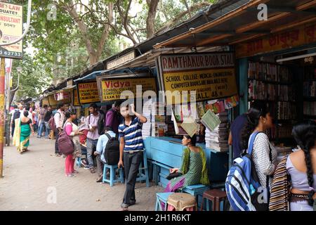 Gli studenti check out libri a una vecchia strada laterale prenota stallo a College Street del mercato del libro in Kolkata, India Foto Stock