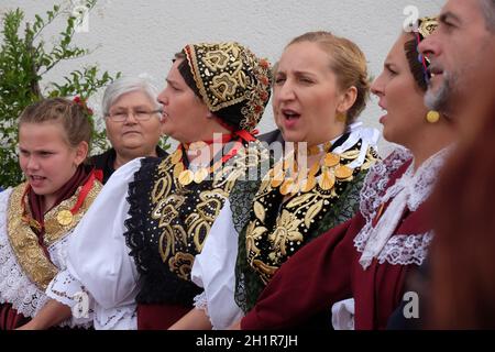 La gente di cantare e ballare dopo la Messa per la Giornata del Ringraziamento in Stitar, Croazia Foto Stock