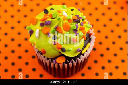 Halloween Cupcakes a tema con Sprinkles su un tavolo arancione e nero Foto Stock