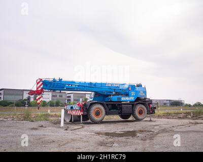 La gru per cantieri sta sollevando un cartello a LED vuoto su sfondo blu cielo per la nuova pubblicità Foto Stock