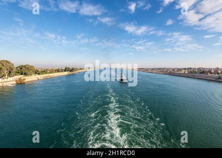 Nave che passa attraverso il canale di Suez in Egitto. Il rimorchiatore accompagna le navi. Foto Stock