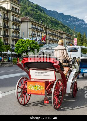 Interlaken, Switzerland - May 26, 2016: Horse carriage waiting for passengers at Interlaken, Switzerland, Europe. Stock Photo