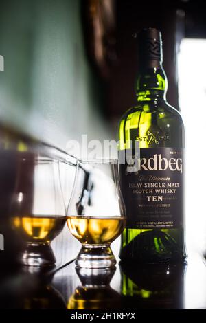 Bucarest, Romania - 3 marzo 2021: Immagine editoriale illustrativa di una bottiglia di whisky di malto singolo di Ardbeg e di un bicchiere di Glencairn in un pub di Buc Foto Stock