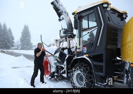 Der Fahrer der Großen Schneeschleuder befreit die Technik vom festen nassen Altschnee Starker Wintereinbruch im Landkreis-Breisgau Hochschwarzwald. R Foto Stock