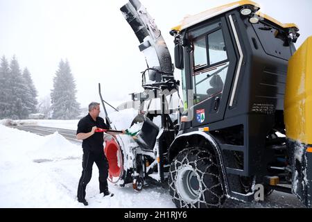 Der Fahrer der Großen Schneeschleuder befreit die Technik vom festen nassen Altschnee Starker Wintereinbruch im Landkreis-Breisgau Hochschwarzwald. R Foto Stock