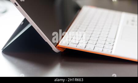 Close-up di bianco arancione notebook convertibile e la tastiera Foto Stock