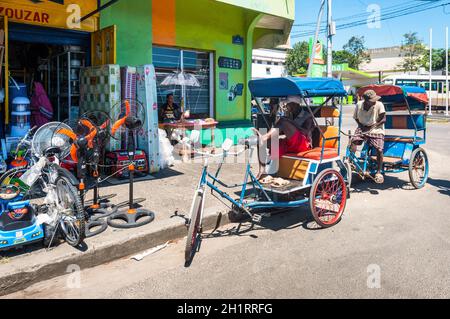 Toamasina, Madagascar - 22 Dicembre 2017 : malgascio rickshaws conducente in appoggio con il suo tipico rickshaw padicab, tradizionale trasporto in Toamasina Foto Stock