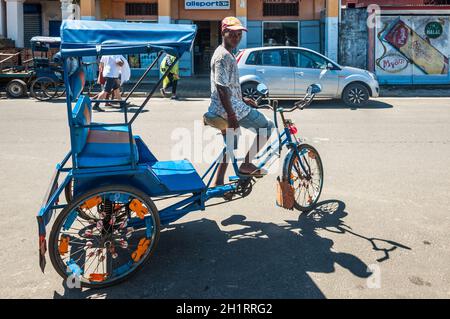 Toamasina, Madagascar - Dicembre 22, 2017: uomo malgascio, riscio', è a riposo in attesa per i clienti di Toamasina (Tamatave), Madagascar, East Af Foto Stock