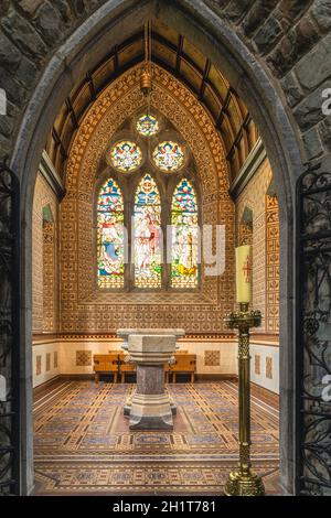 Killarney, Irlanda, agosto 2019 interni, aspersorio o stoup e vetrate in una piccola sala laterale nella cattedrale di St. Marys Foto Stock