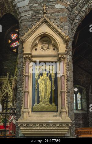 Killarney, Irlanda, agosto 2019 interno, primo piano sulla scultura o rilievo di un santo su colonna nella Cattedrale di St. Marys Foto Stock