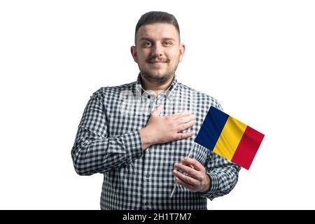 Ragazzo bianco che tiene una bandiera del Ciad e tiene la sua mano sul suo cuore isolato su uno sfondo bianco con amore per il Ciad. Foto Stock