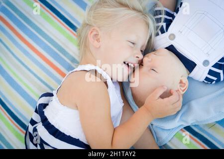 Carino Sorellina posa accanto al suo fratellino sulla coperta. Foto Stock