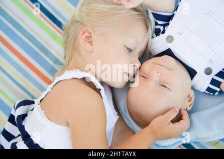 Carino Sorellina posa accanto al suo fratellino sulla coperta. Foto Stock