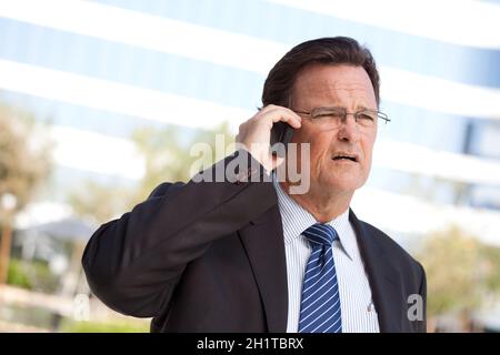 Preoccupato, ha sottolineato businessman colloqui sul suo cellulare. Foto Stock