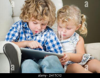 Adorabili giovane fratello e sorella di usare i loro computer Tablet insieme. Foto Stock