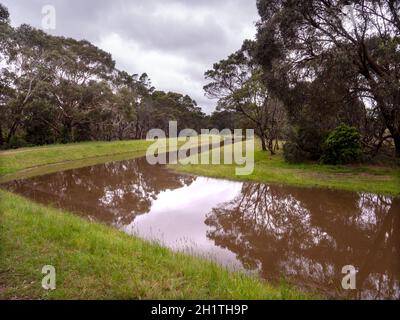 Scarico completo dopo forti piogge primaverili alla riserva naturale Devilbend sulla penisola di Mornington, Victoria, Australia. Foto Stock