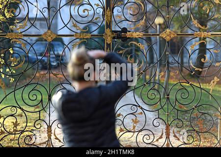 Herbstimmung am Attersee, eine Fotograpfin macht eine Detailaufnahme vom Eingangstor zum Schloss Kammer - l'umore d'autunno all'Attersee, un fotografo Foto Stock