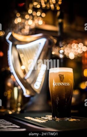 Bucarest, Romania - 25 febbraio 2021: Immagine editoriale di primo piano illustrativa di una pinta di birra Guinness sul bancone di un pub. Foto Stock