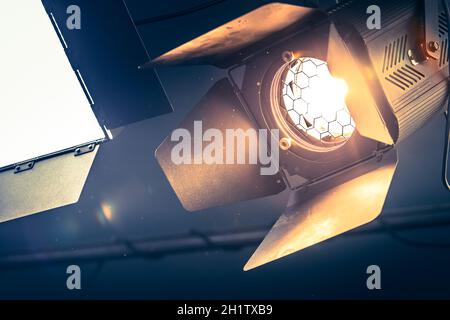 Professional studio arancione spotlight appesi al soffitto. Foto Stock