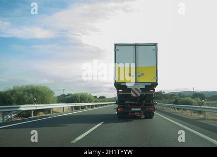 Autocarro per traino pesante che trasporta il semirimorchio sulla superstrada. Limitazioni dell'altezza del carrello e concetto di distanza ponte Foto Stock