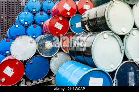 Vecchi barili chimici su pallet di legno. Tamburo dell'olio blu e rosso. Serbatoio dell'olio in acciaio e plastica. Magazzino dei rifiuti tossici. Contenitore per sostanze chimiche pericolose. A industriale Foto Stock