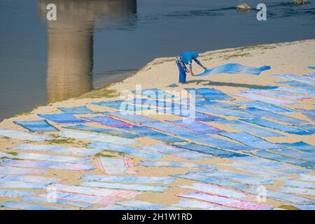 La gente indiana che lava il panno sulle rive sabbiose del fiume Yamuna ad Agra, India. Foto Stock